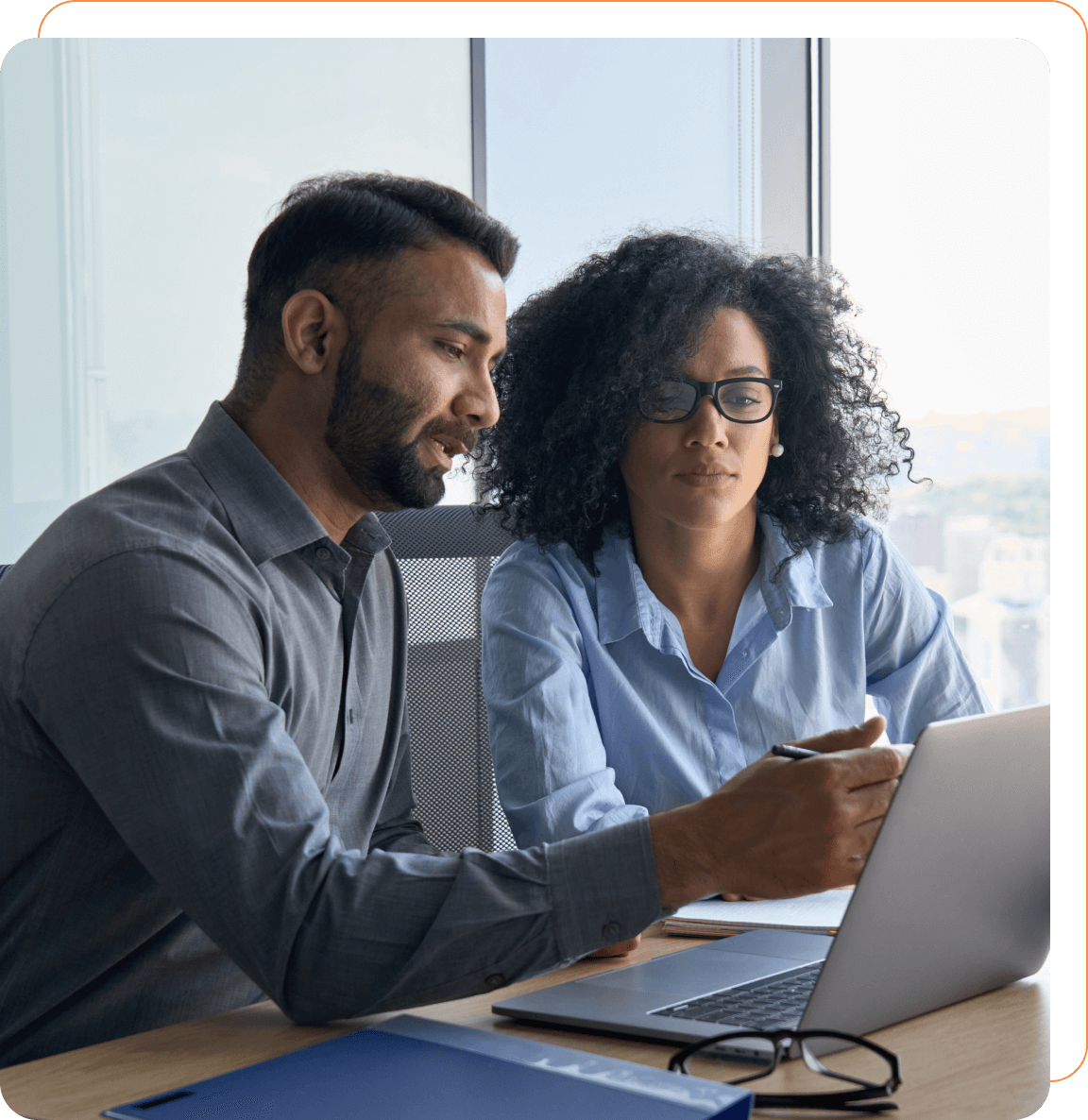 A man and woman looking at a laptop.