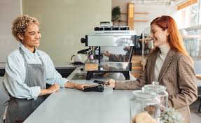 Barista and customer exchanging payment at counter.