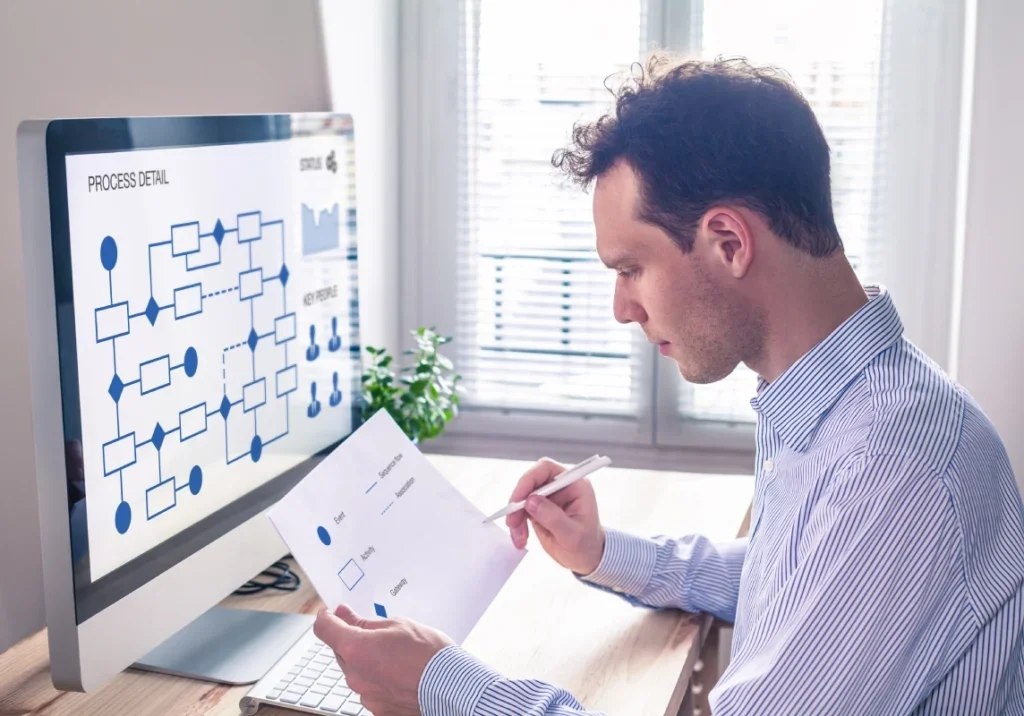 A man sitting at his desk looking at a paper.